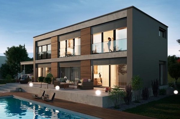 Modernes Einfamilienhaus mit Terrasse und Pool im Garten bei Sonnenuntergang.